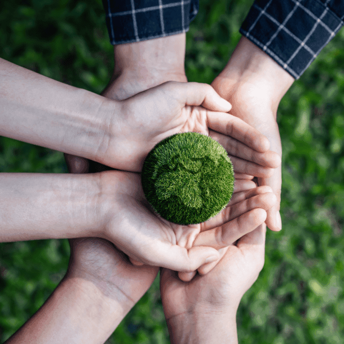 People's hands hugging a handmade globe to protect the planet together in World Earth Day concept